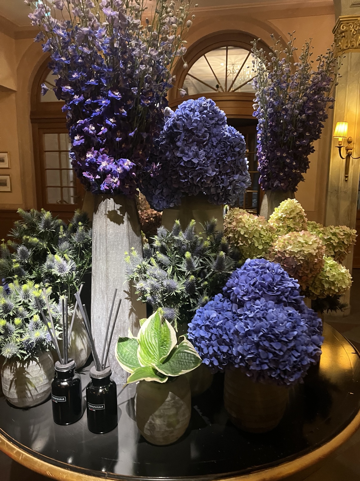 Üppige violette und blaue Blumenarrangements in einem festlichen Innenraum